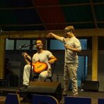 Gabriel Cheib ao lado de violonista Rafael Cheib, sobre o palco
