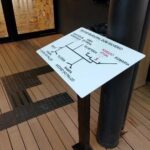 piso tátil preto sobre piso de madeira e mapa tátil do Teatro Dom Silvério
